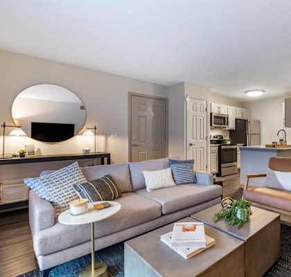 a living room with a couch and a table and a kitchen at Roswell Village in Roswell, Georgia