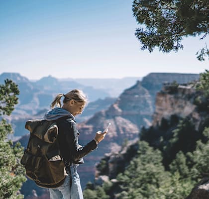 A woman with a backpack is standing in a natural landscape. at Spring Meadow Apartments, Glendale, AZ, 85302