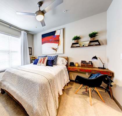 bedroom with bed and desk with a ceiling fan