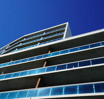 a tall building with blue windows against a blue sky