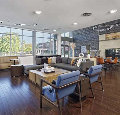 A modern living room with a grey couch and blue chairs.