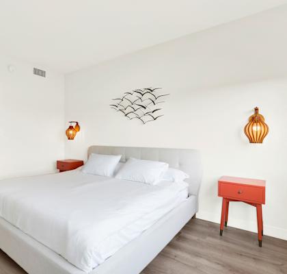 A bedroom with a white bed and a red stool at Twelve One Ten Rochester, California