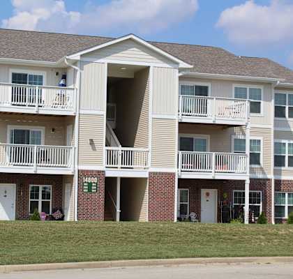 a building with two balconies and a lawn at Salem Place Apartments, Daleville, 47334