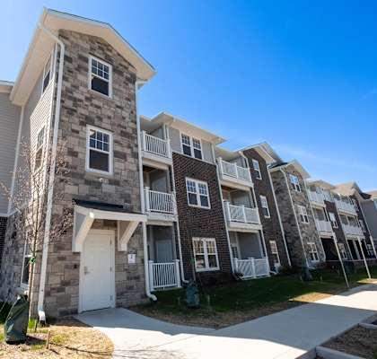 an apartment building with a stone exterior and white doors at Ritchey Reserve, Fishers, 46038