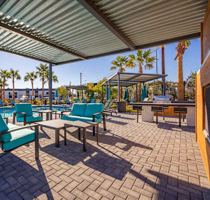 A patio with a table and chairs under a roof.