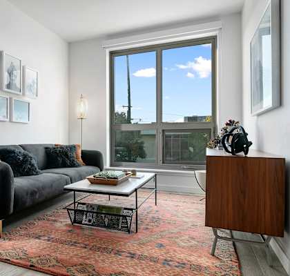 A living room with a black couch and a coffee table.
