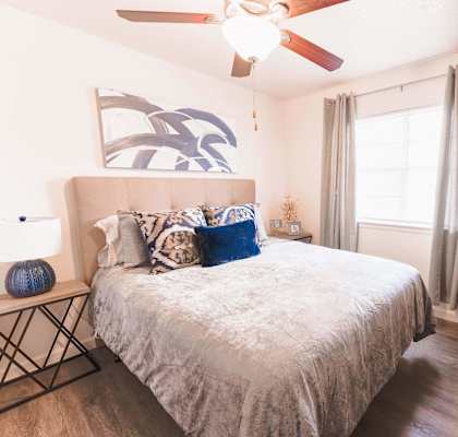 a bedroom with a bed and a ceiling fan
