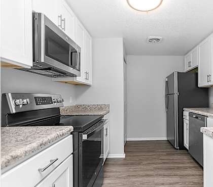 a kitchen with white cabinets and black appliances at Gull Harbor Apartments in New London, CT, 06320