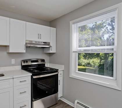 a kitchen with white cabinets and black appliances and a window at Hawkins Meadow in Amherst, MA, 01002