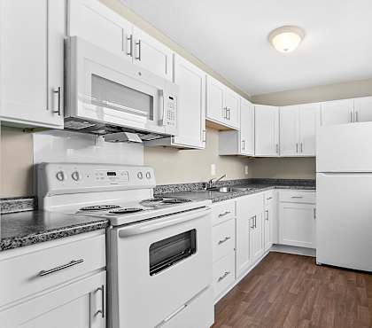 a white kitchen with white appliances and white cabinets at Rose Hill Estates, Connecticut, 06360