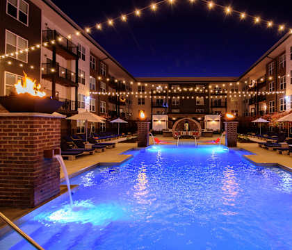 A pool lit up with blue lights at night.