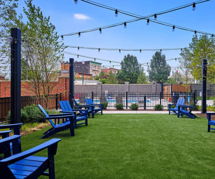 a yard with blue lawn chairs and a pool in the background at Shearwood Station, New York