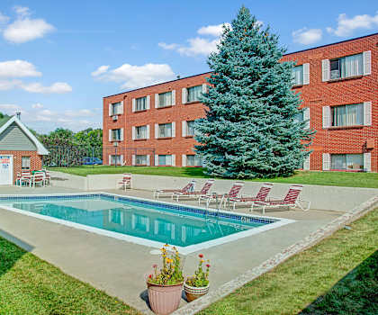 The outdoor pool with pool chairs, tables, and chairs at Bristol Square Apartments.