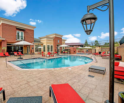The outdoor pool with pool chairs, tables, and chairs at Elements at Briargate. 