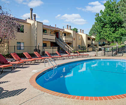 The outdoor pool with pool chairs, tables, and chairs at Grand View. 