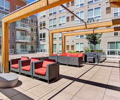 Outdoor resident lounge at 7west with red cushioned couches and reds. 