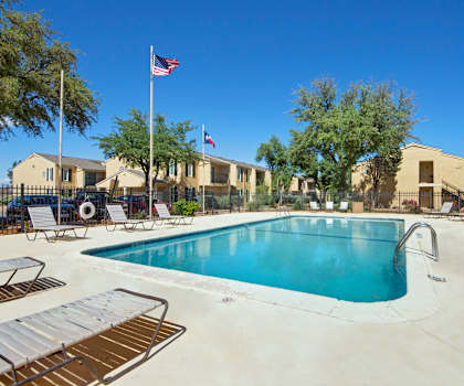 Turquoise swimming pool at Avalon Springs with surrounding pool chairs. 