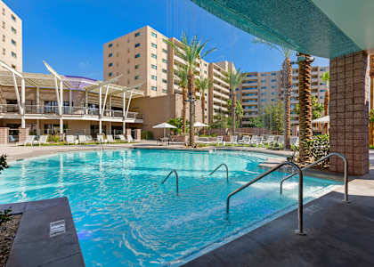 a swimming pool with a building in the background at The Rays at Vegas Towers Apartments, Las Vegas