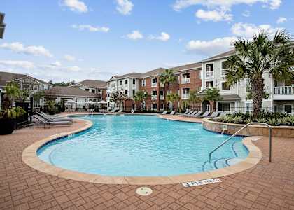 a large swimming pool in front of an apartment building at Volare at the Woodlands, The Woodlands, TX