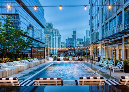 Wooden chair beside pool at Flair Tower Apartments, Chicago, IL