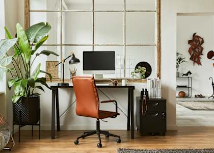 a home office with a computer desk and a leather chair