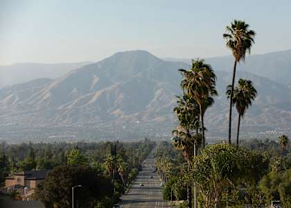 a view of the mountains from a street with palm trees at Aspire Redlands, California, 92374