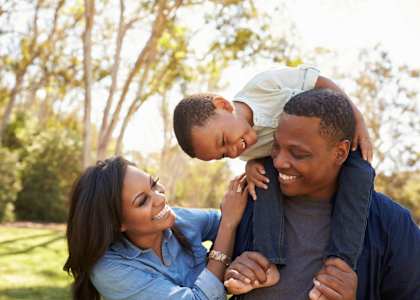 A family of three enjoying a sunny day outdoors.