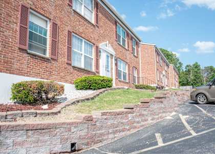 A brick building with a car parked in front.