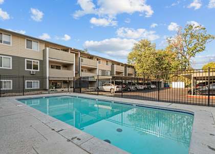 A swimming pool in front of apartment buildings.