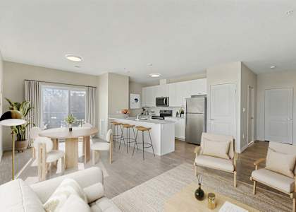 A modern living room with a kitchen in the background.