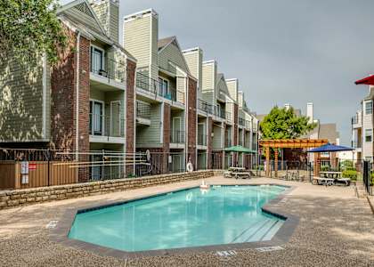 A swimming pool in front of apartment buildings.
