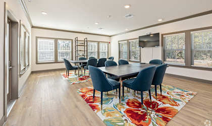 A dining room with a large table and chairs.