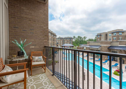 a balcony with a swimming pool and a patio with chairs at Residence at Riverwatch in Augusta, GA 30909