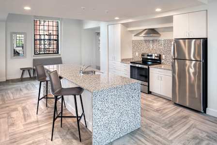 A kitchen with a granite countertop and a refrigerator.at The Residences at St. Elizabeths East, Washington District of Columbia