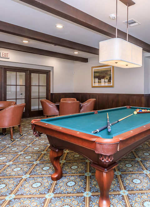 a pool table in a game room with chairs at Mariposa at Westchester, Grand Prairie, 75052