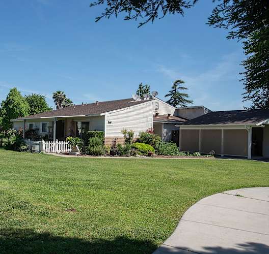 a white house with a yard in front of it at Castle Vista Senior Duplex Community, Atwater, California
