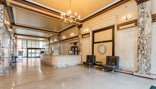 A large, elegant room with a marble floor and a clock on the wall at Mohican Apartments, New London, CT, 06320