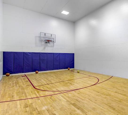 a basketball court in a gym with a wooden floor