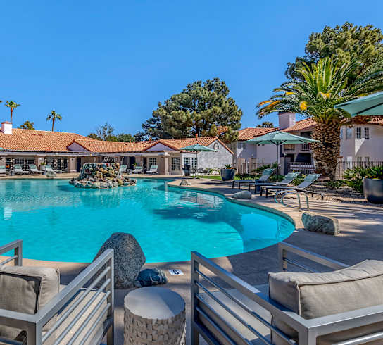 a large swimming pool with chairs and umbrellas at the resort