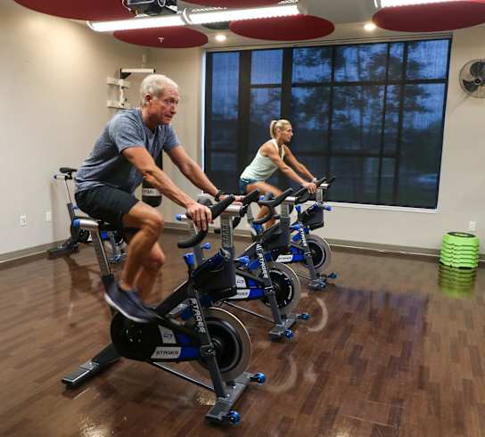 a man and a woman riding exercise bikes in a gym at Bluestone Flats, Duluth, MN
