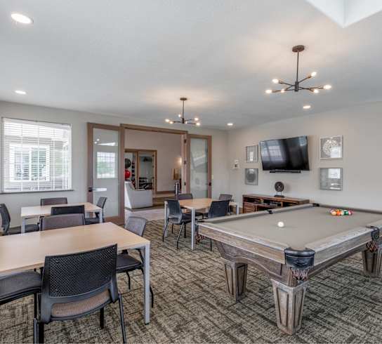 A room with a pool table and a television.
