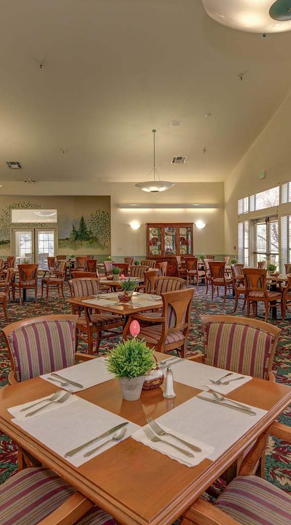 a large dining room with tables and chairs and windows  at Castle Vista Senior Duplex Community, Atwater, CA