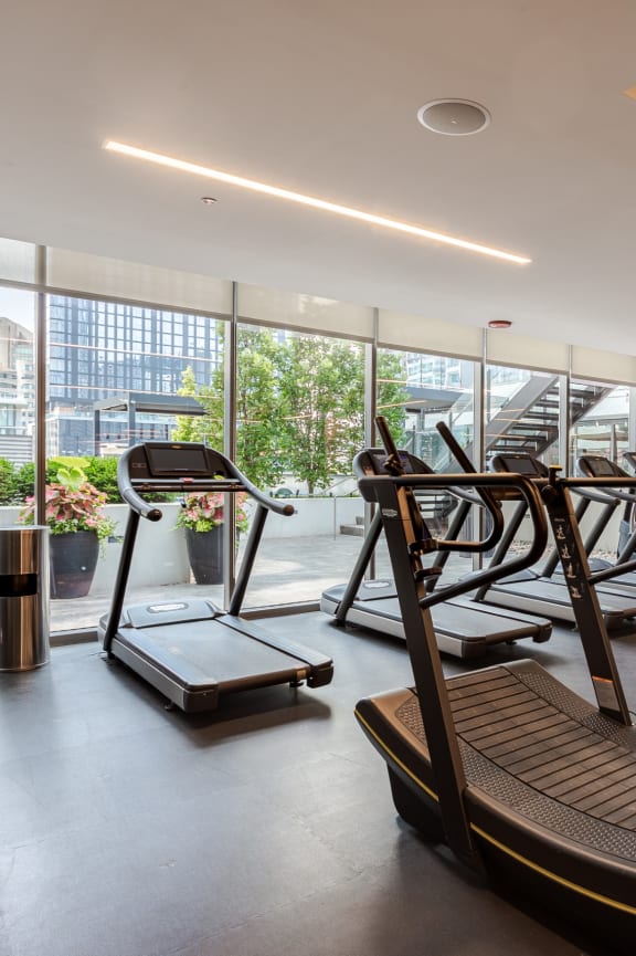 a woman running on a treadmill at the gym at The Grand Central, Illinois, 60607