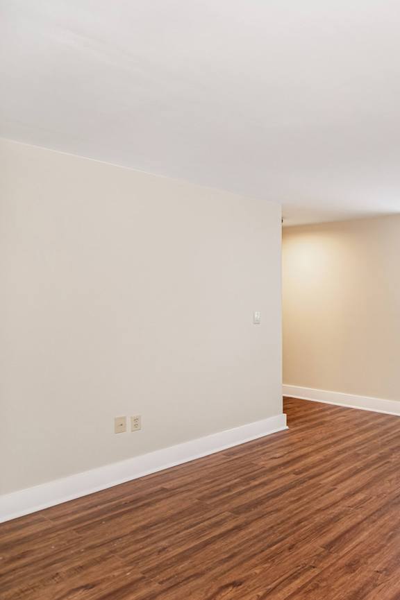 an empty living room with wood flooring and a window at Retro 511 Apartments, West Haven