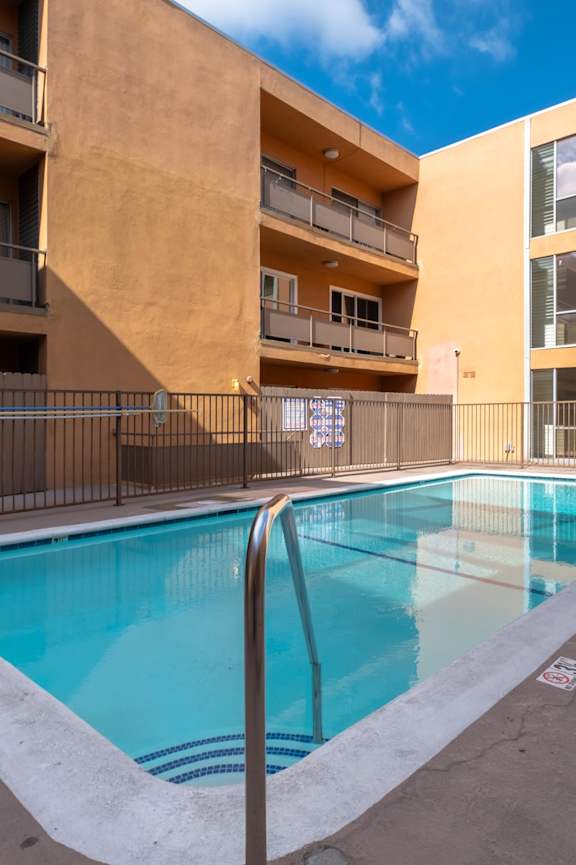 A small pool in a courtyard surrounded by buildings. at Menlo Terrace Apartments, Los Angeles