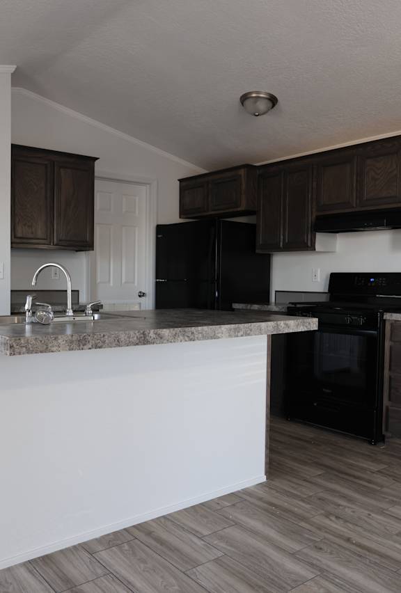 an empty kitchen with an island in the middle of it at Horizon MHC, Rock Springs, WY 82901