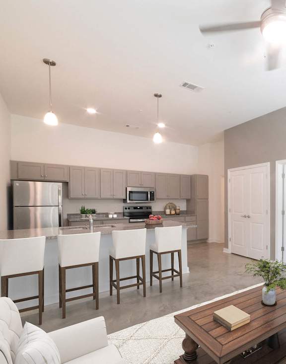a living room and kitchen with a couch and a tv
