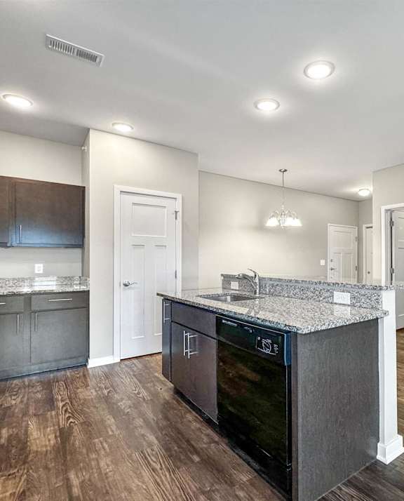 A kitchen with dark wood floors and a granite countertop at The Barclay Apartments, Altoona, IA, 50009