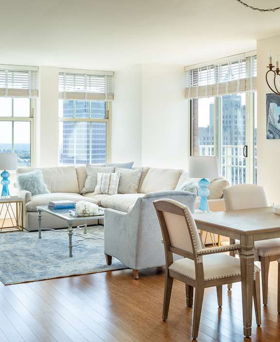 A living room with a white couch and a wooden table at Residences Providence, Rhode Island 2903