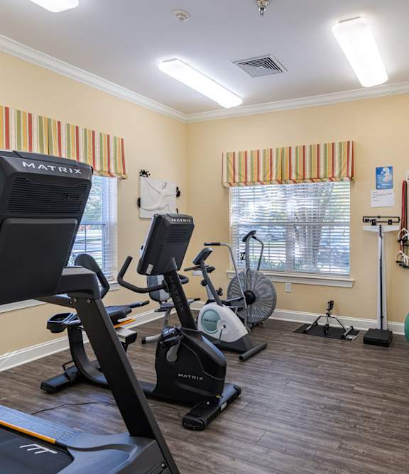 A gym with a treadmill, exercise bike, and other equipment.at The Gardens of Stafford, Stafford, VA 22556
